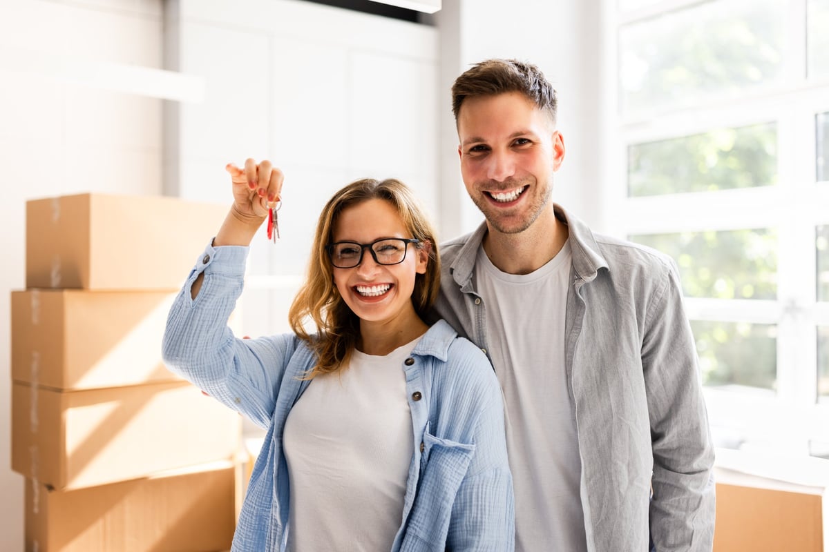 Happy Couple Moving Into New House Holding Keys