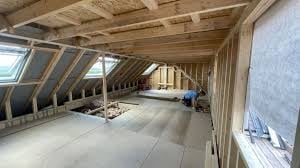 Empty attic space with exposed wooden beams and framing under construction