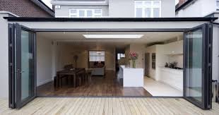 Modern open-plan home extension with bifold doors, light wood flooring, and contemporary interior design featuring kitchen and living areas