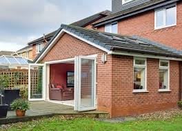 Red brick house with white conservatory extension and attached garage